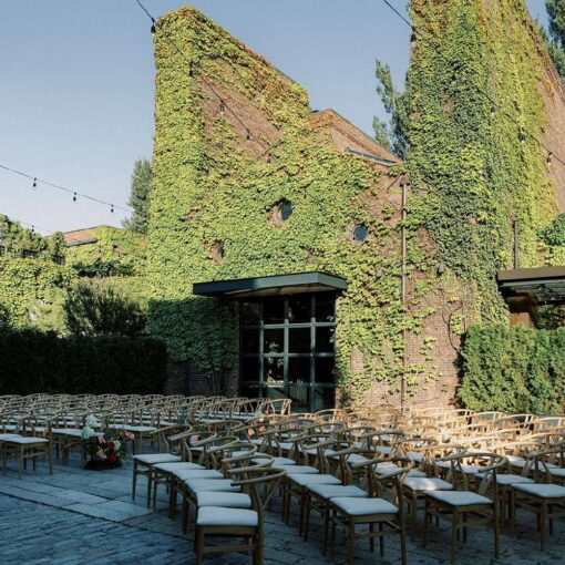 Ceremony chairs in the courtyard for Tina & Real's outdoor NYC wedding reception at The Foundry with String Lights hanging overhead.