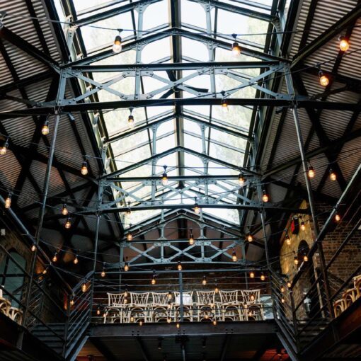 String Lights hanging overhead inside the main reception room for Gianna + Steven's summer wedding at The Foundry