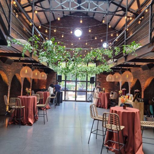 Hanging rattan lanterns, Up-Lights, and String Lights paired with earthy hues and bold tropical florals, helped create a relaxed African-infused wedding at The Foundry.