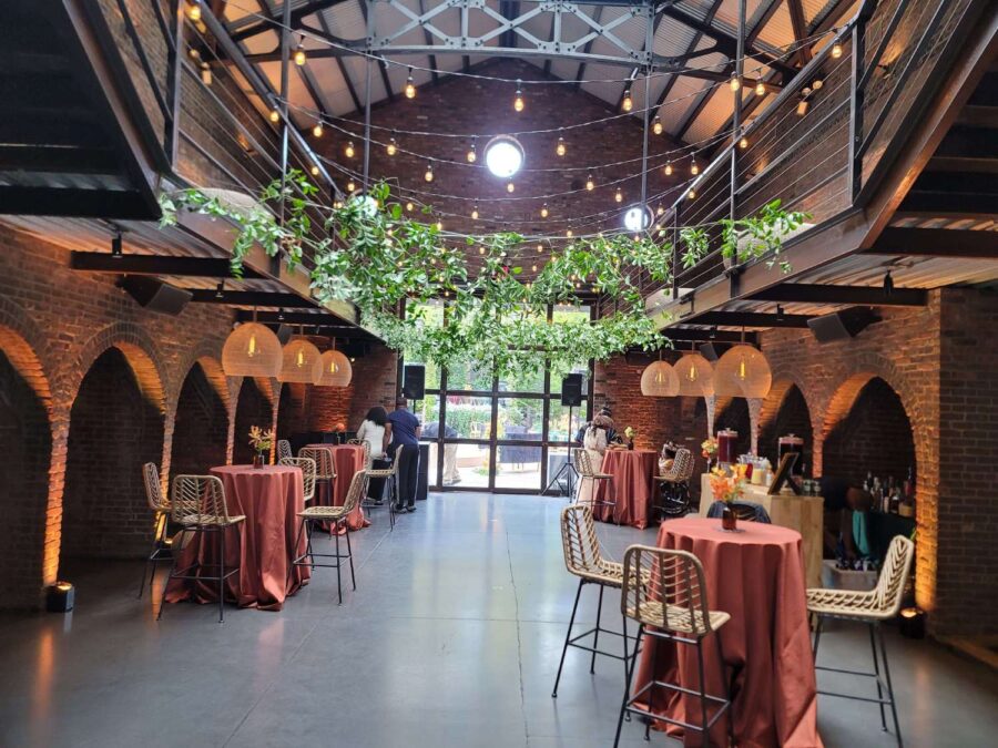 Hanging rattan lanterns, Up-Lights, and String Lights paired with earthy hues and bold tropical florals, helped create a relaxed African-infused wedding at The Foundry.