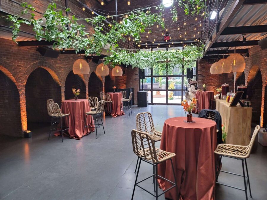 Hanging rattan lanterns, String Lights, and Up-Lights, paired with earthy hues and bold tropical florals, helped create a relaxed African-infused wedding at The Foundry.