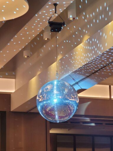 A rotating Mirror Ball hang from the ceiling for a wedding in The Constellation Ballroom at The TWA Hotel.
