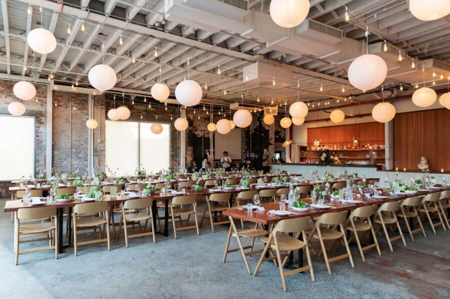 Zigzag string lights with paper lanterns hanging in The Corner Room for Julia + Ray's wedding reception at Rule of Thirds in Brooklyn, NY.