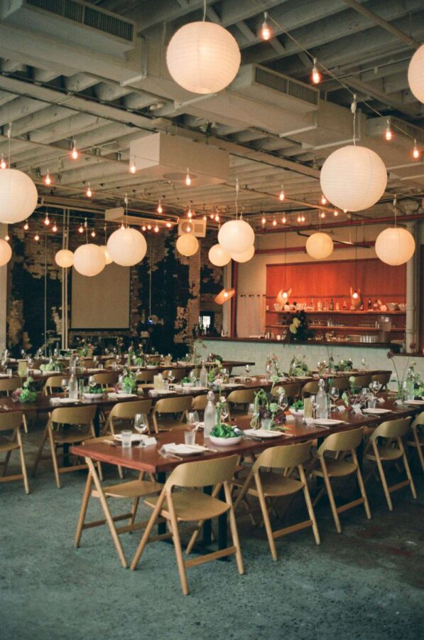 Zigzag string lights with paper lanterns hanging in The Corner Room for Julia + Ray's wedding reception at Rule of Thirds in Brooklyn, NY.