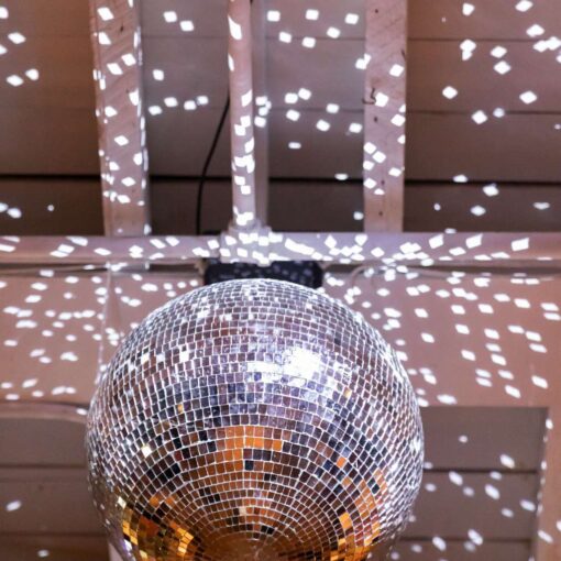 A rotating mirror ball in The Atrium at Arden and Keith’s vibrant and colorful Brooklyn wedding at Rule of Thirds.