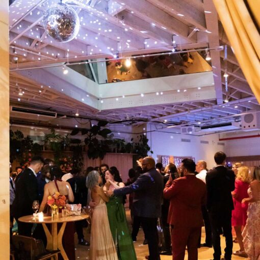 A rotating mirror ball in The Atrium at Arden and Keith’s vibrant and colorful Brooklyn wedding at Rule of Thirds.