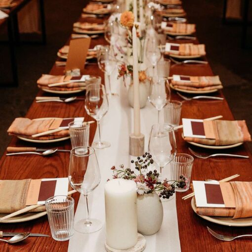 Bryan and Chris utilized long wooden tables meticulously set for a dining event, featuring elegant decor, soft lighting, and a refined atmosphere in The Corner Room for a wedding at Rule of Thirds. Bryan and Chris utilized long wooden tables meticulously set for a dining event, featuring elegant decor, soft lighting, and a refined atmosphere in The Corner Room for a wedding at Rule of Thirds.