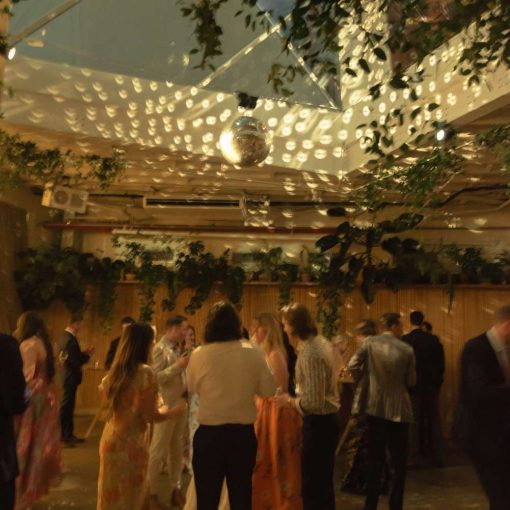 A rotating Mirror Ball hanging in The Atrium above the dance floor and String Lights hanging in The Corner Room at Rule of Thirds in Brooklyn, NY.