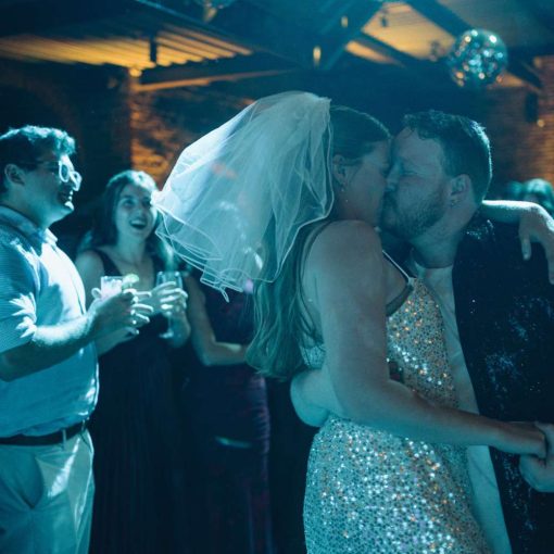 Sophie and David are dancing in the main room at the Foundry under mirror balls with a turquoise color wash. Sophie and David are dancing in the main room at the Foundry under mirror balls with a turquoise color wash.